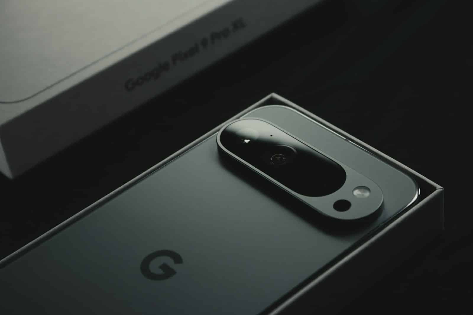 A close up of a cell phone near a laptop